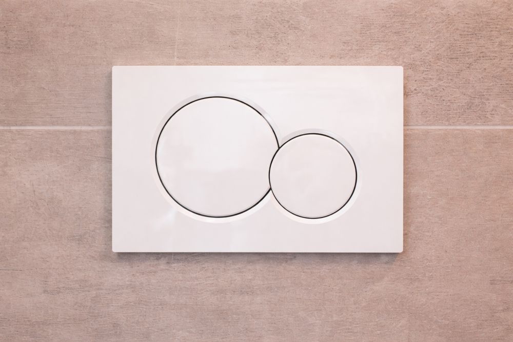 Minimalistički taster ugradnog vodokotlića postavljen na zid kupatila